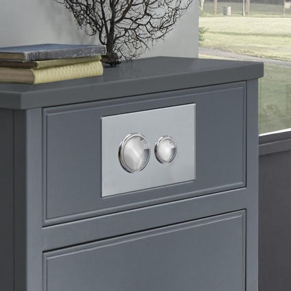 product lifestyle image of Roper Rhodes Chrome Traditional Dual Flush Button fitted to grey back to wall unit TR9019